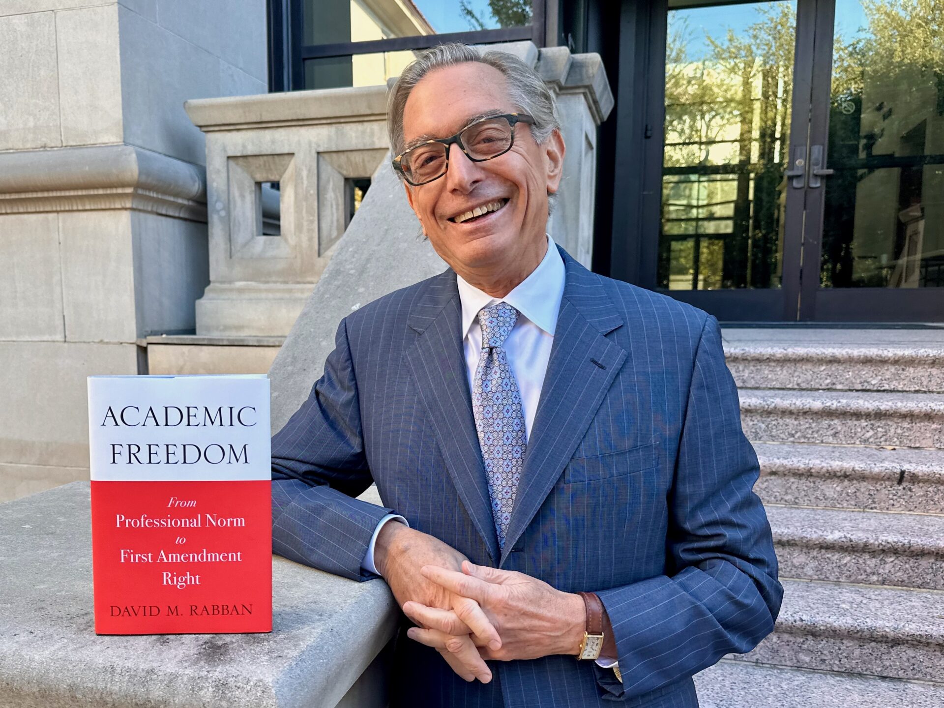 Photo of David Rabban in a suit standing outside with his new book, "Academic Freedom". #TexasLawFaculty