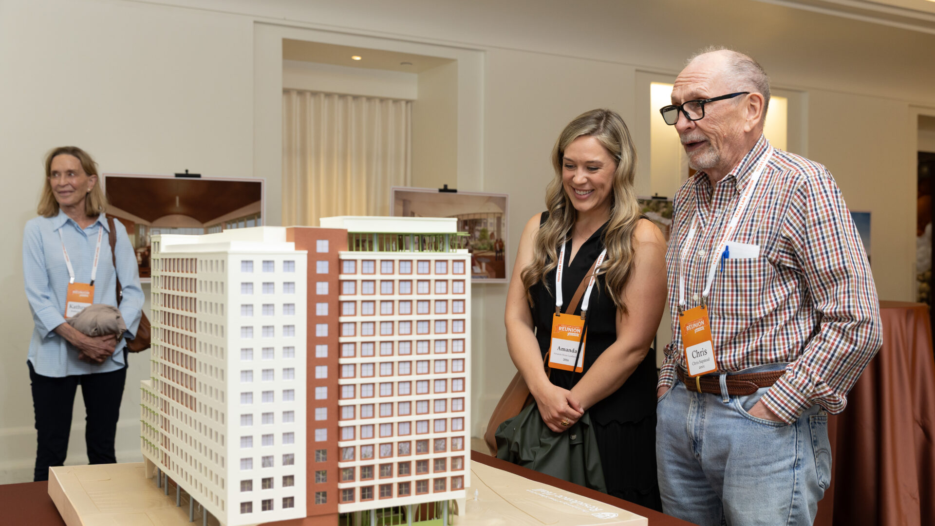 Alumni admiring residence hall model at Reunion 2026