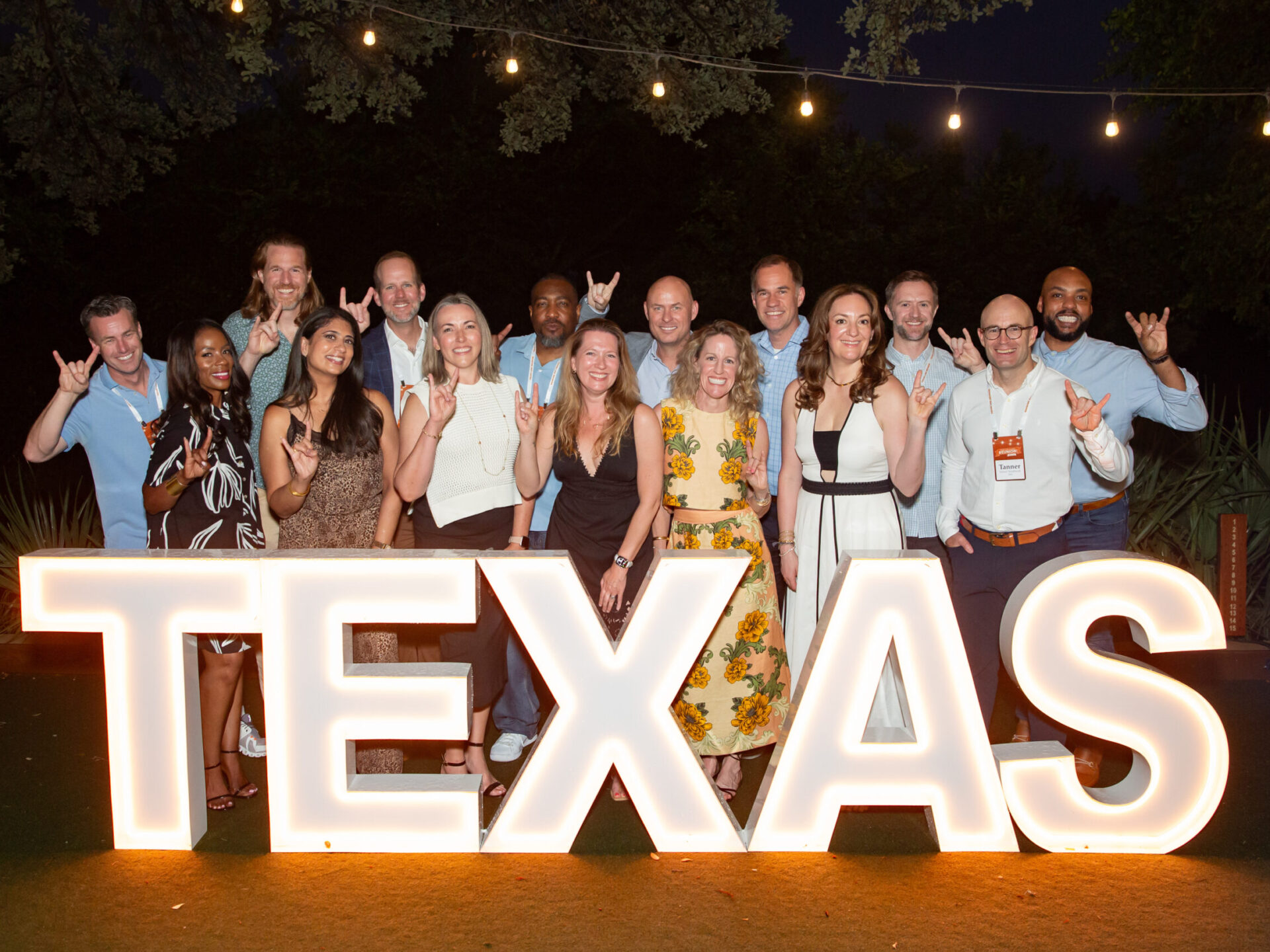 Photo of alumni behind Texas Law sign with lights
