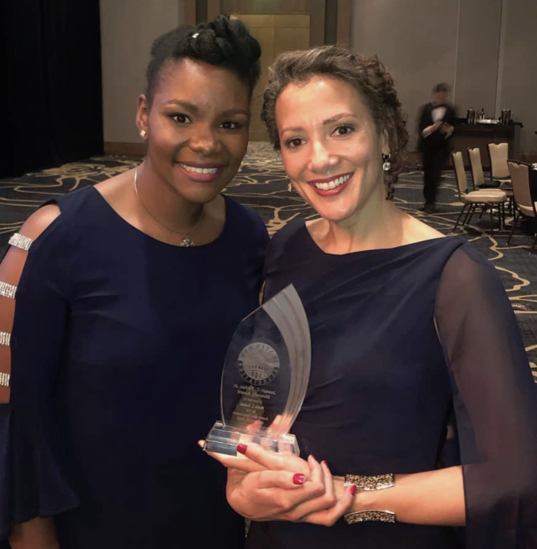 Professor Nelia Robbi, holding an award