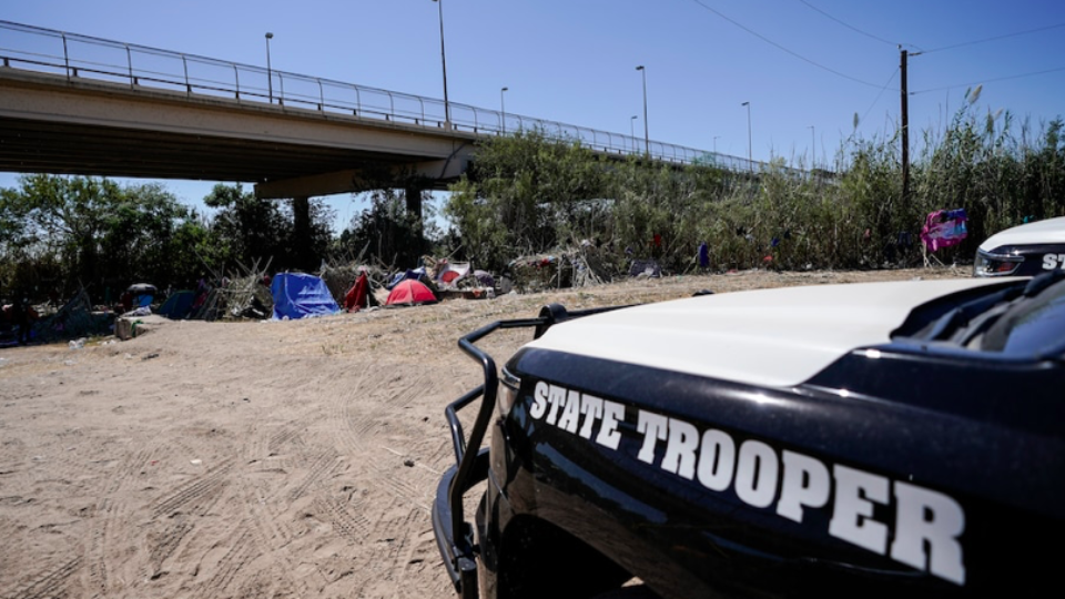 A State trooper car near migrant tents