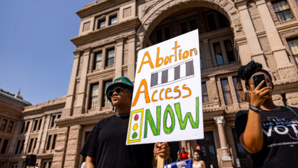 Abortion activists with sign "Abortion Access Now"