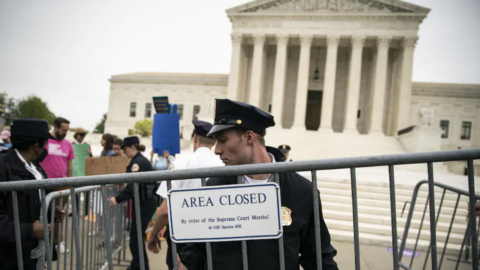 A police officer sets up a barricade during a protest outside of the Supreme Court on May 3.