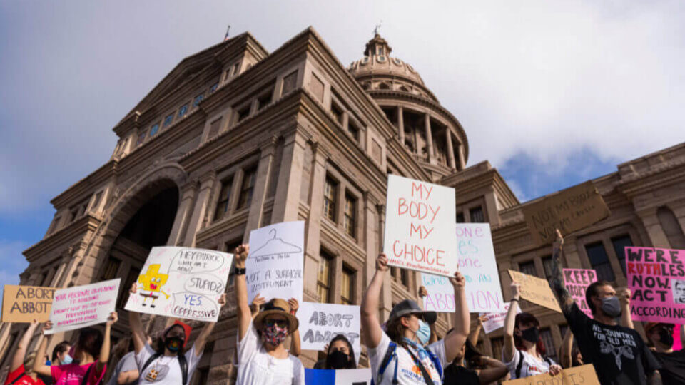Protesters stand at the front steps of the state Capitol in opposition to Texas’ abortion restrictions law