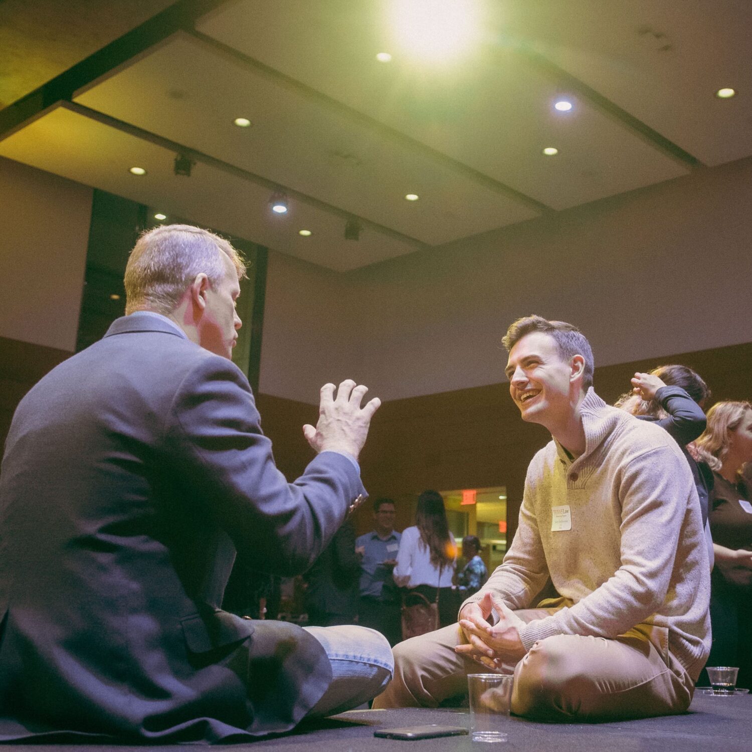Alumnus mentor talking with student mentee at an event.