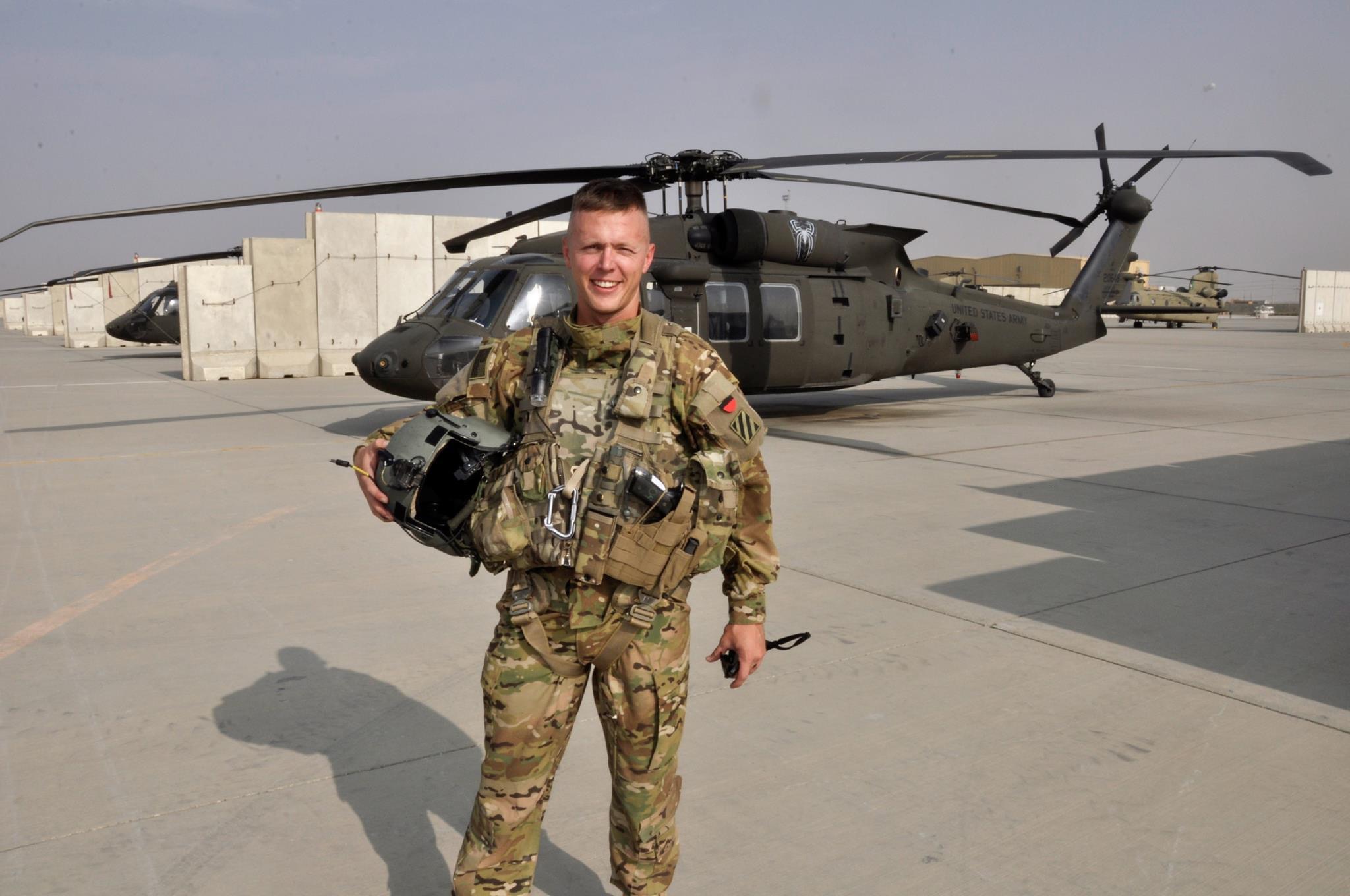 Josh Davis '21 stands in uniform in front of his Black Hawk helicopter