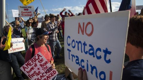 Anti-contact tracing protestors hold signs