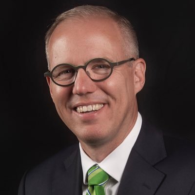 Portrait of Taylor, Texas Mayor Brandt Rydell wearing glasses and a green tie.