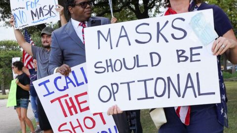 Anti-mask demonstrators outside Houston Independent School District building holding signs that say "Masks should be optional"