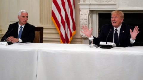 Mike Pence and Donald Trump sitting at opposite sides of a table speaking