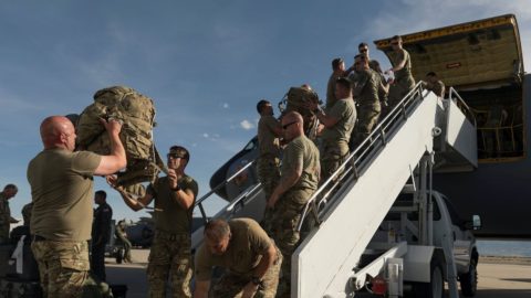 Soldiers load bags onto a KC-135R aircraft