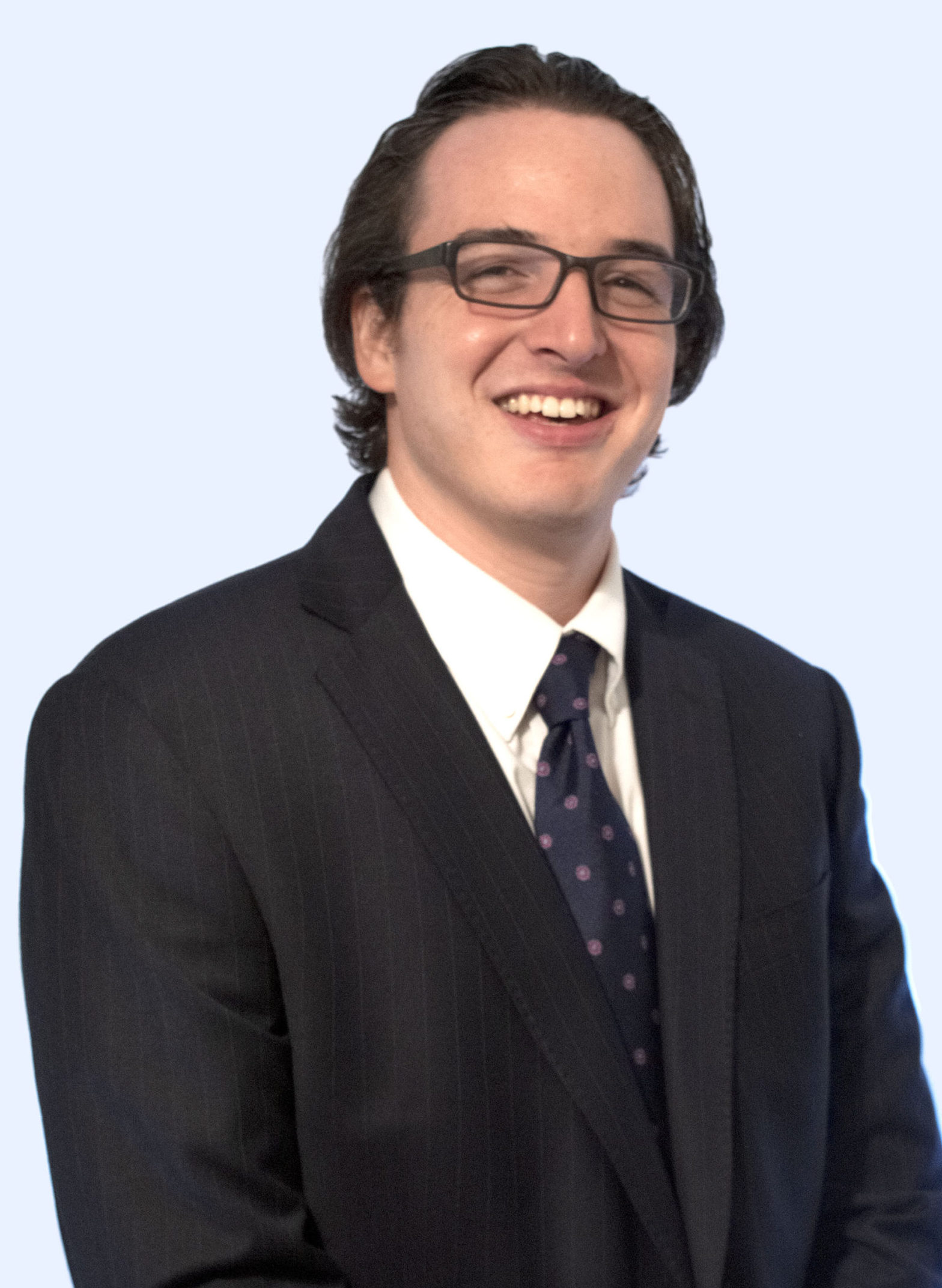 Headshot of Pierce Smith, wearing glasses and a suit with a blue and pink polka dot tie.