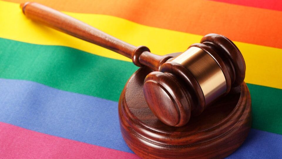 Pride flag with a law gavel sitting on top of it.