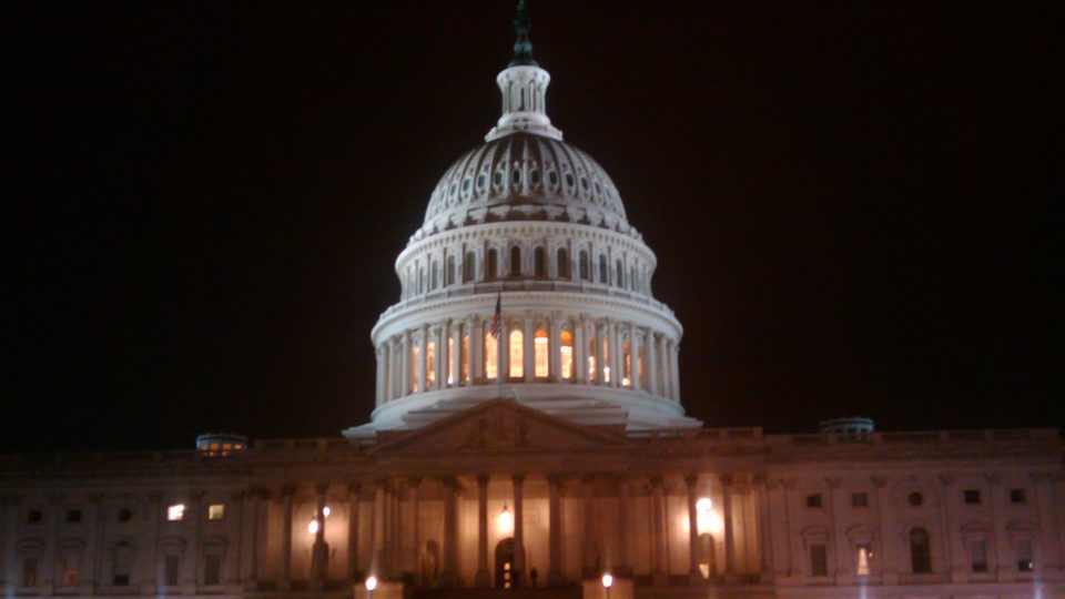 The U.S. Capitol at night with the lights on, looking foggy.