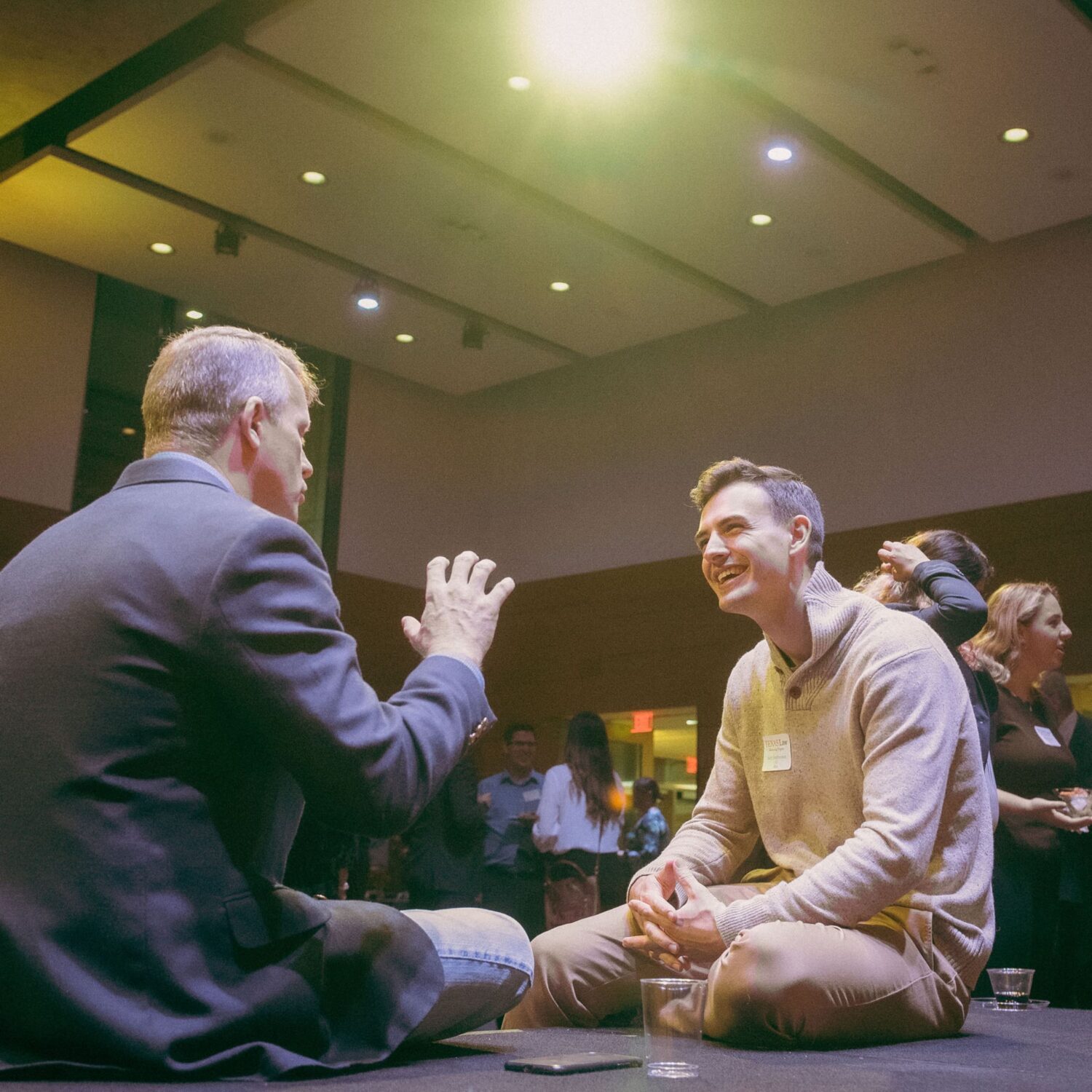 Alumnus mentor talking with student mentee at an event.
