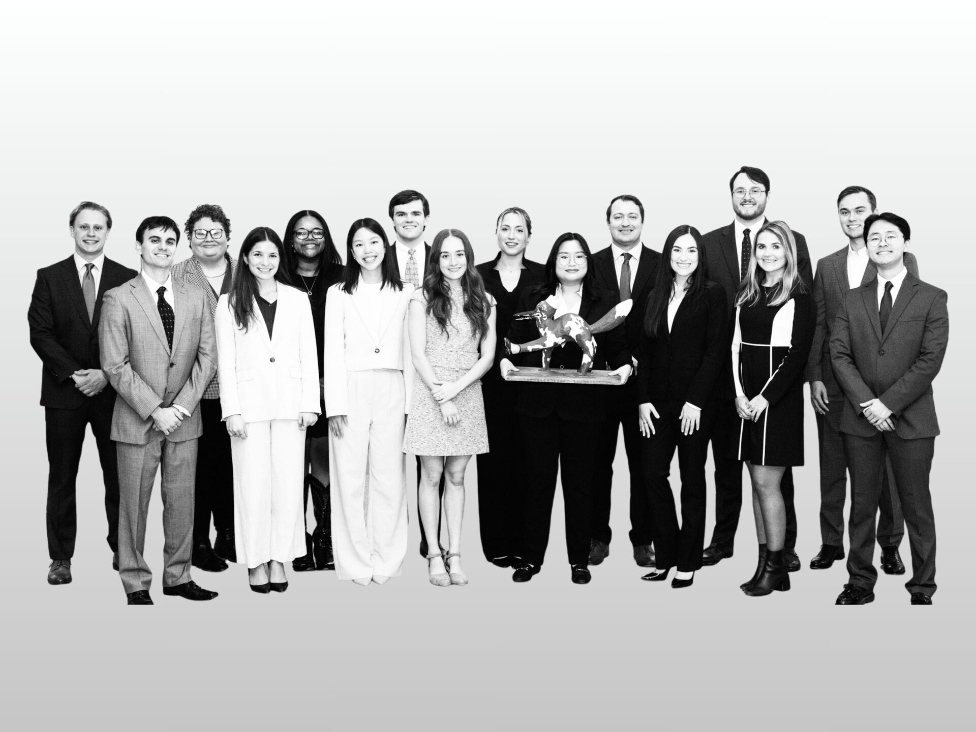 A black and white image of Texas Law's 16 Chancellors with one holding the Peregrinus statue, on an ombre grey background