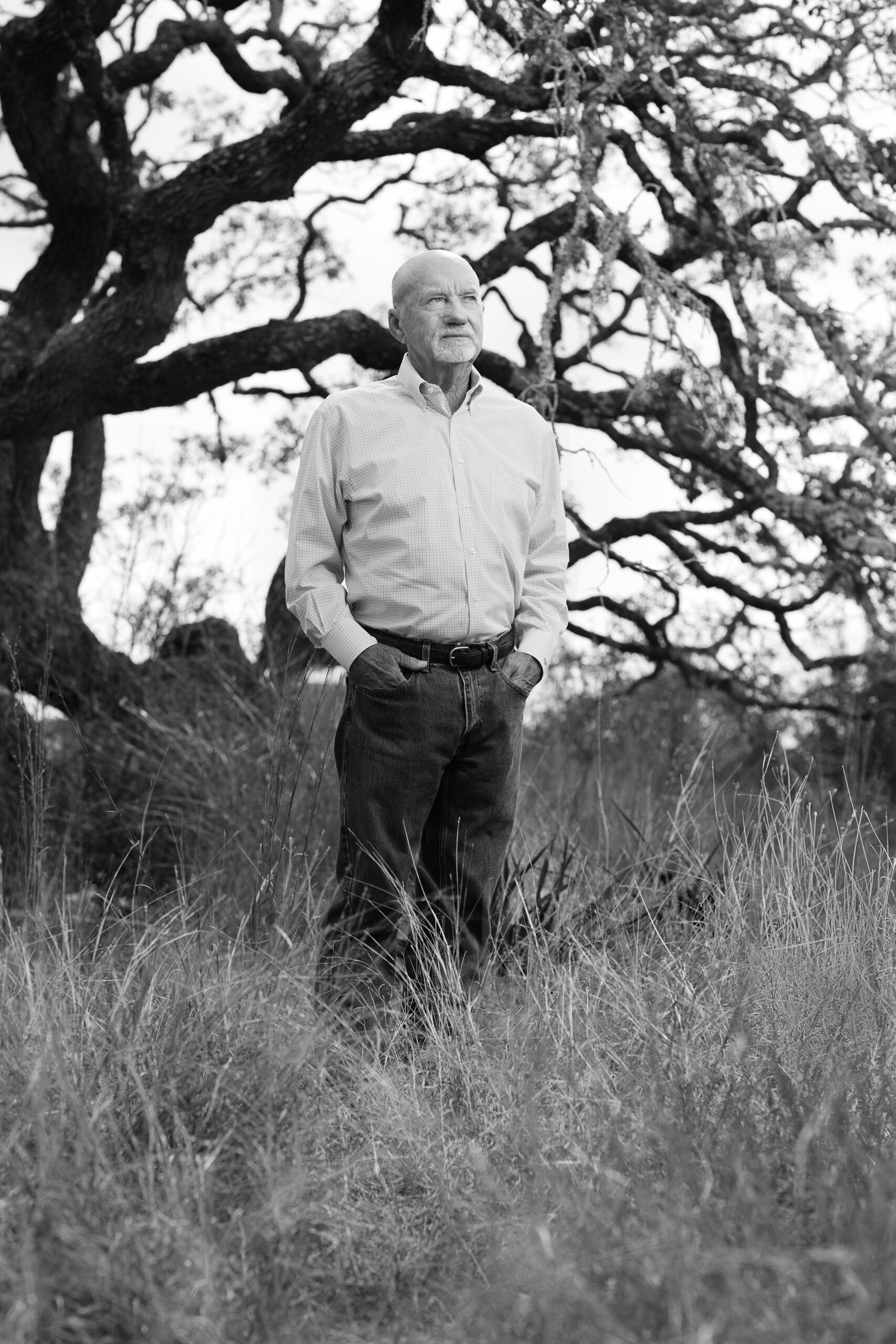 Black and white photo of Guy James Gray Jr. standing by large tree
