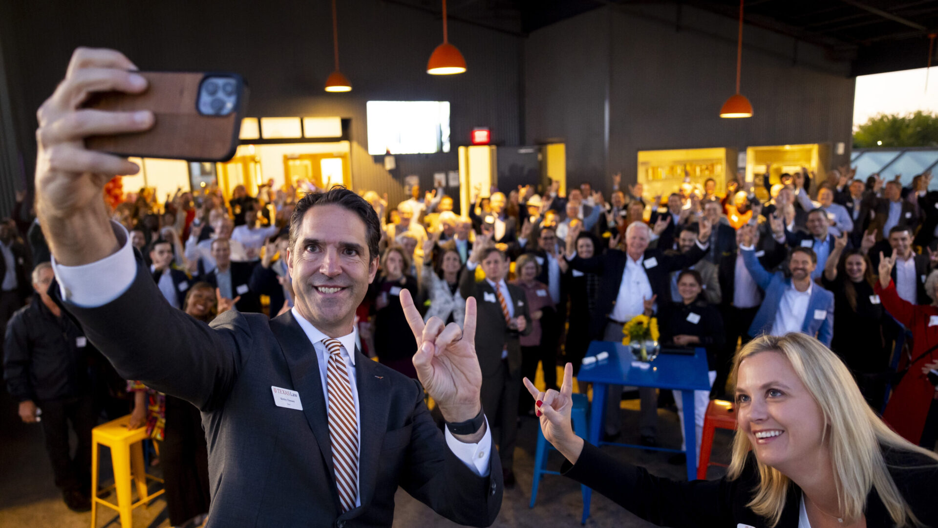Dean Chesney taking a selfie with a number of alumni at a Texas law on Tour event