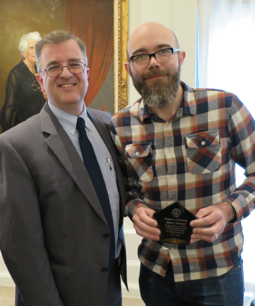 Adam Norwood accepts his Employee of the Year Award from Dean Farnsworth