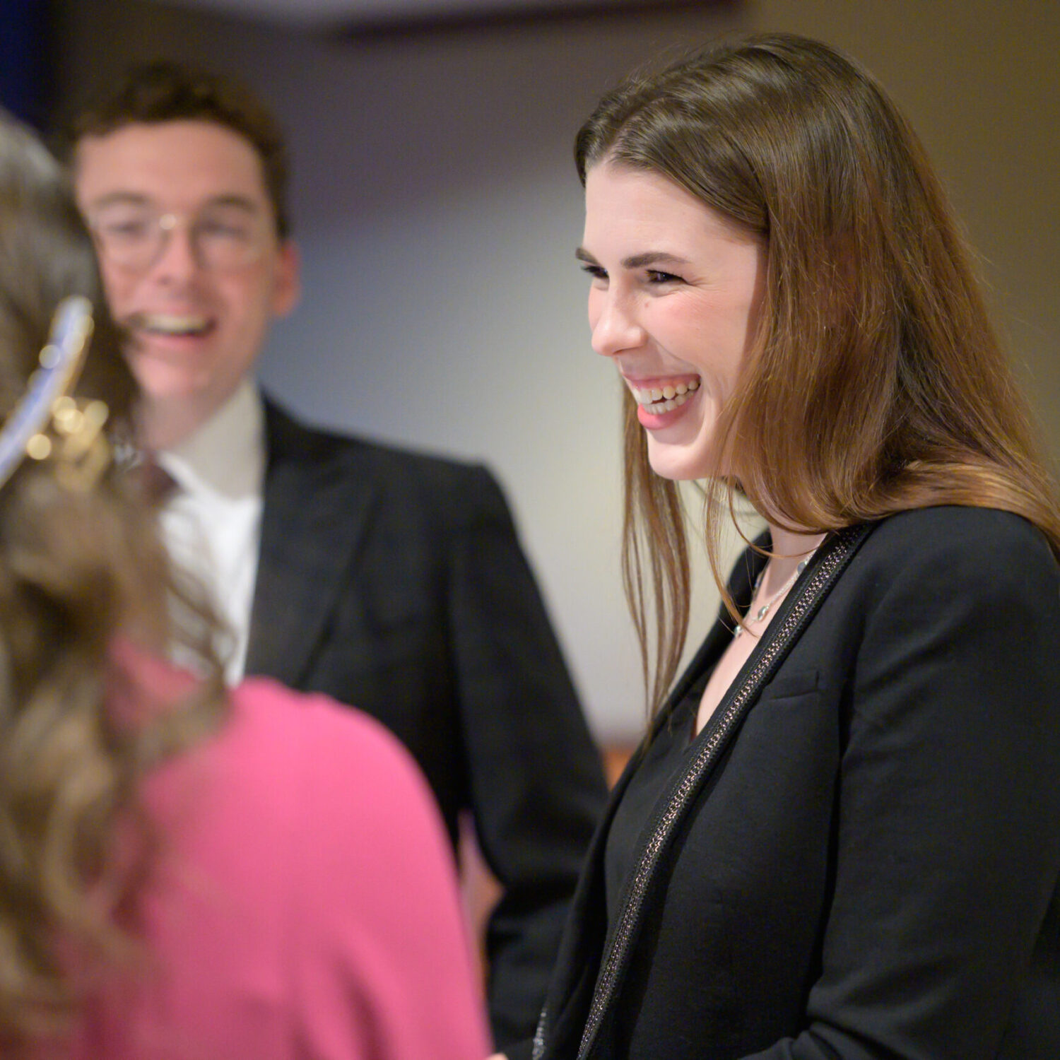 female law student wearing a suit, smiling in conversation