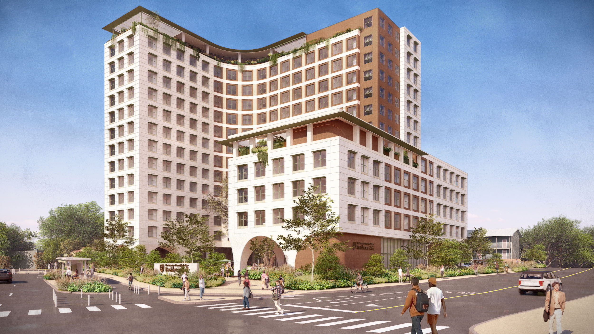 Corner exterior view of the residence hall from the Dean Keaton and Medical Arts intersection. Students walk through a crosswalk in the foreground. The building features a curved facade, arched entrance, and rooftop greenery.