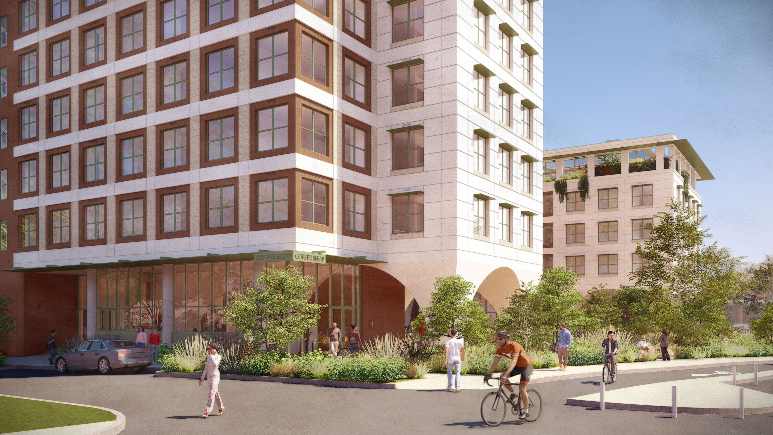 Street-level view of the base of the residence hall on Dean Keeton and Hampton with a café at ground level. Pedestrians walk along a landscaped path and a cyclist rides by in the foreground.